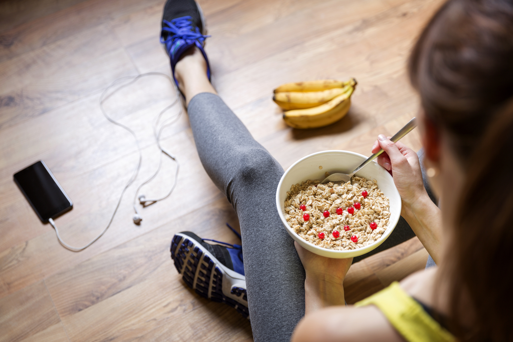 femme en tenue de sport mangeant un bol de céréales pour le petit-déjeuner